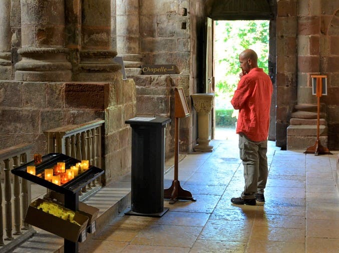 pelerin en priere dans eglise pelerinage compostelle randonnee spirituelle