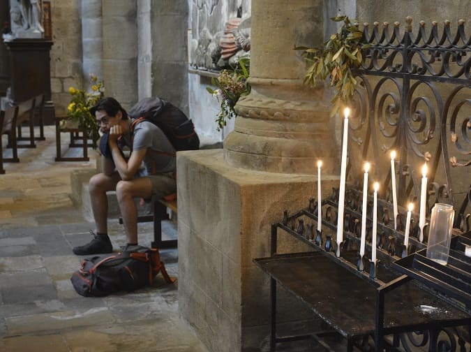 pelerin en méditation dans la basilique de conques